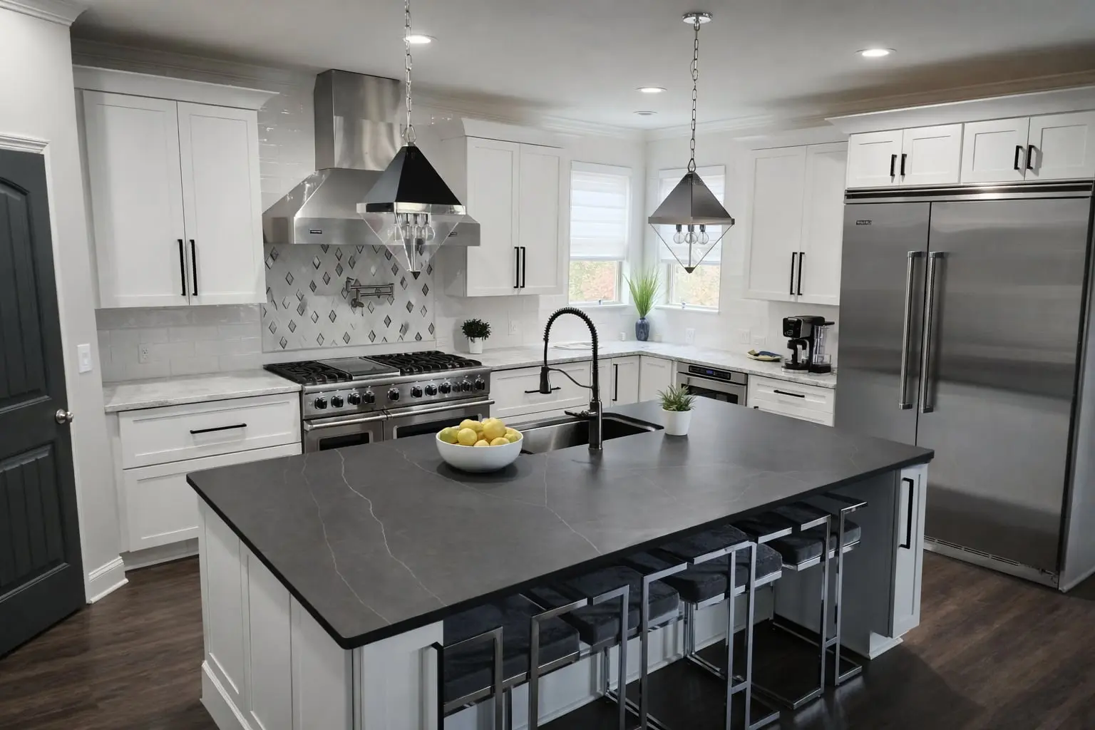 Kitchen with white shaker cabinets, a charcoal-topped island with bar stools, a diamond-tile backsplash and glass pendants